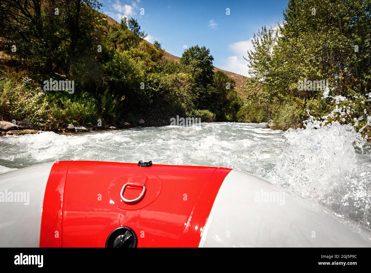 Schaum und Spray um das Paddel in der Hand auf dem Rand eines Floßes Rafting auf einem Bergfluss. Stockfoto