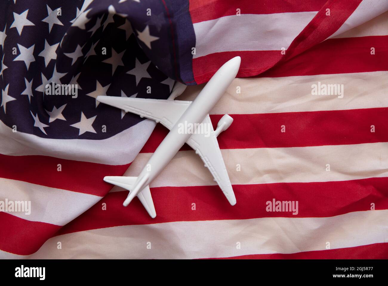 Flughintergrund der Vereinigten Staaten. Flugzeugspielzeug auf einer Start- und Streifenflagge Stockfoto