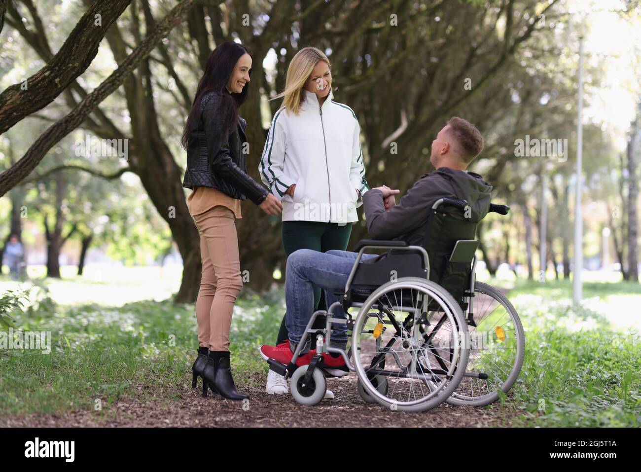 Mann im Rollstuhl und lachende Frau im Park Stockfoto