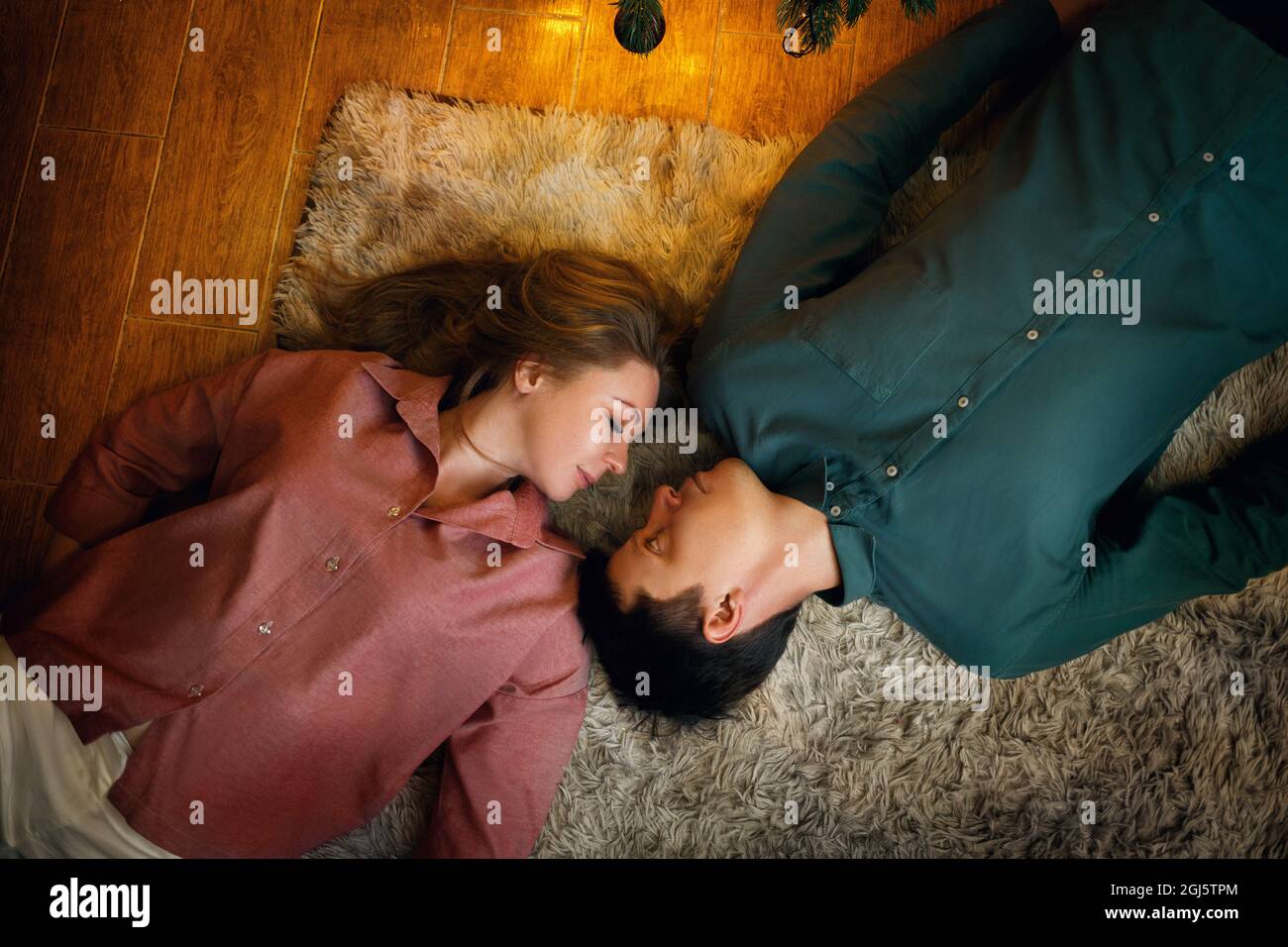 Schöne mittleren Alters kaukasischen Paar liegt auf dem gemütlichen Teppich. Draufsicht. Film Korn-Effekt Stockfoto