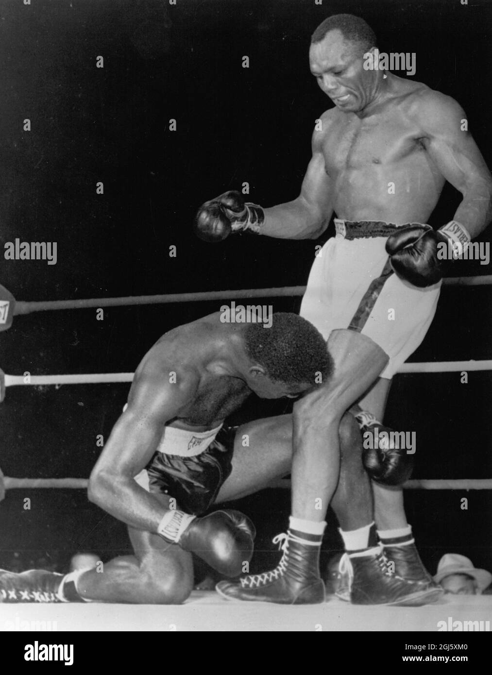 Ezzard Charles geht in der 7. Kampfrunde mit Joe Walcott Undated um die Zählung zurück Stockfoto