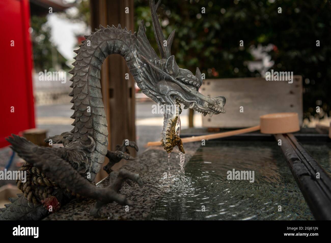 Ein Reinigungsritual mit Wasser aus dem Mund des Drachen in einem Tempel oder Schrein in Japan Stockfoto