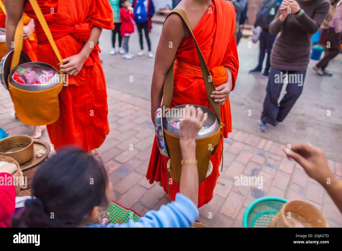 Laos, Luang Prabang. Tak bat im Morgengrauen, Prozession buddhistischer Mönche, die Almosen einsammelten. Stockfoto