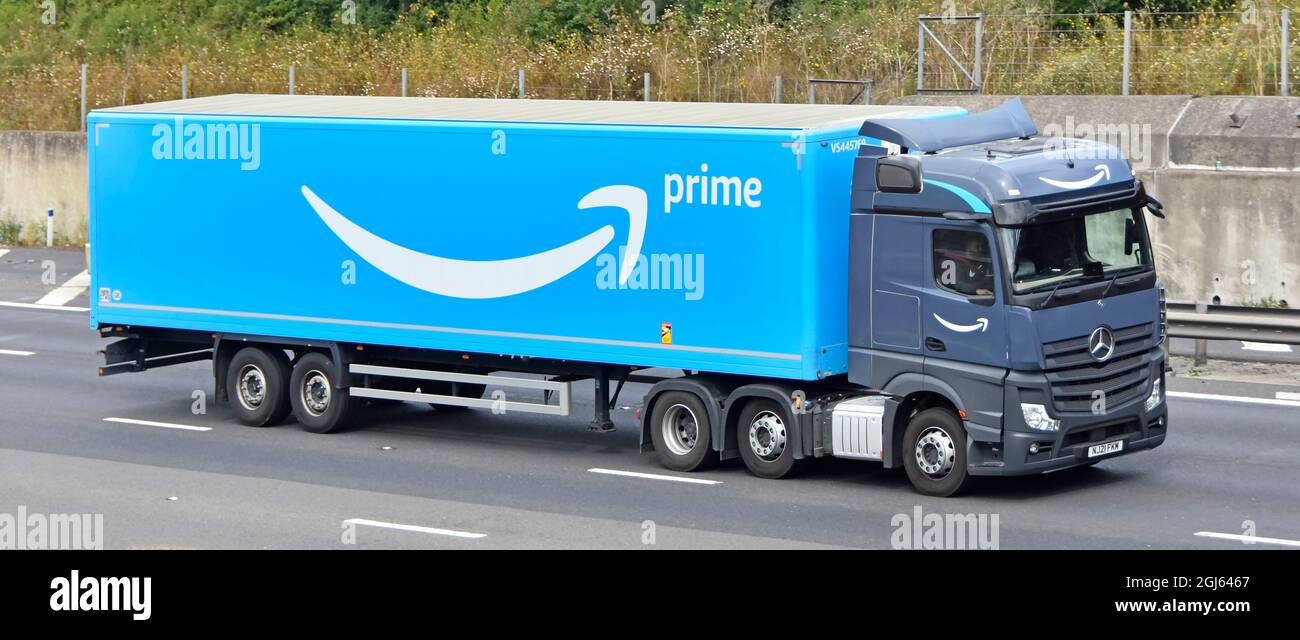 Seite & Vorderansicht des grauen lkw-LKW-LKW blau Amazon Supply Chain  artikulierter Lieferanhänger Fahrer & Logo Marke Werbung Fahren auf der  britischen Autobahn Stockfotografie - Alamy