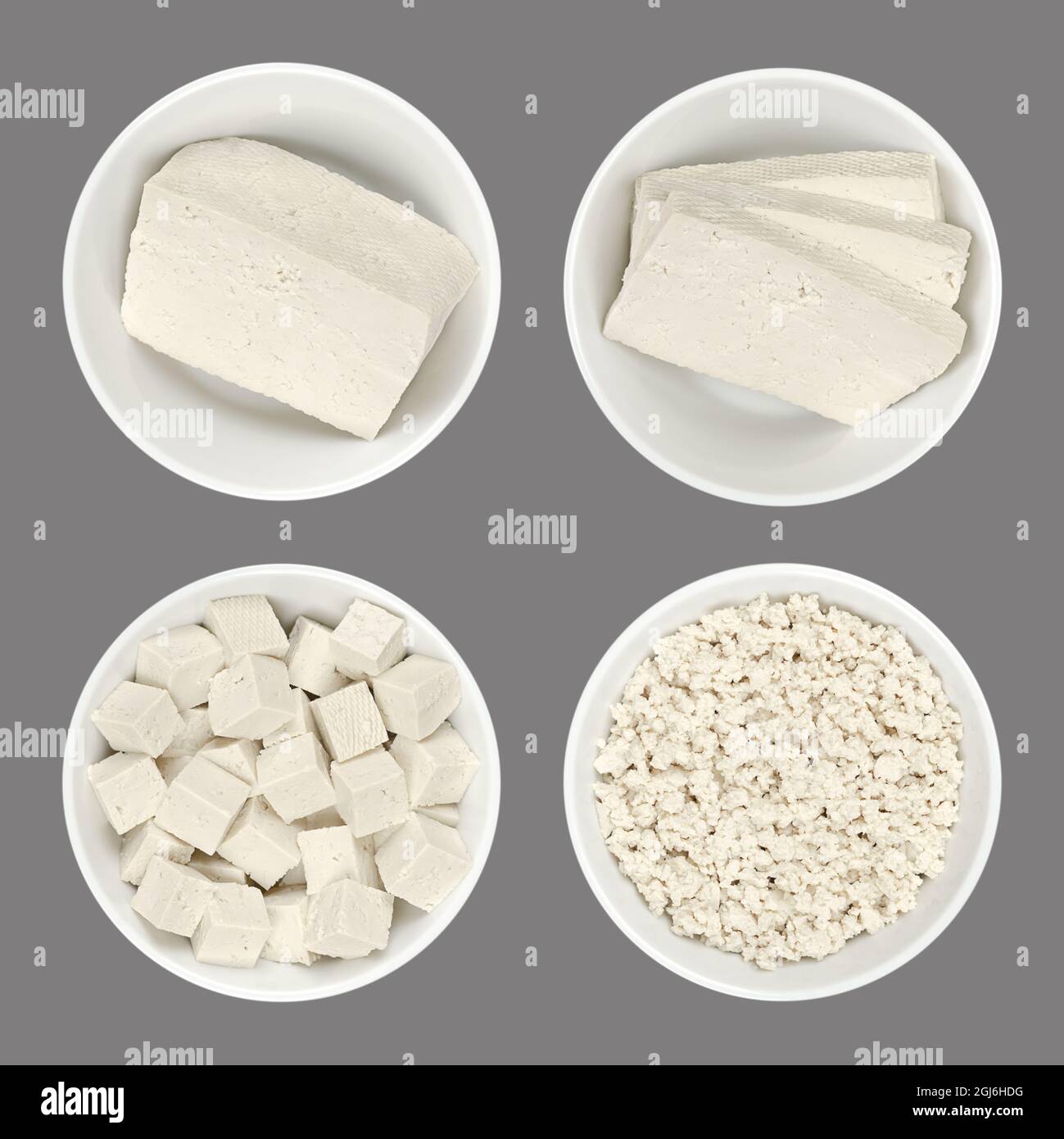 Verarbeiteter weißer Tofu, in weißen Schalen, isoliert auf grauem Hintergrund. Ein Block, Scheiben, Würfel und zerbröckelte Tofu. Bohnenkerz aus gerinnter Sojamilch. Stockfoto