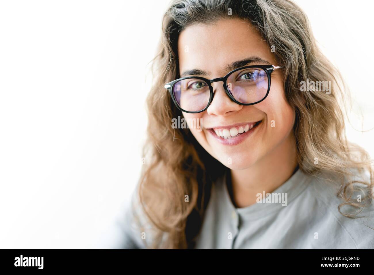 Porträt einer jungen selbstbewussten kaukasischen Geschäftsfrau in Brillen, die lächelnd auf die Kamera blickt. Unternehmertum für eine bessere Lebensqualität, isoliert Stockfoto
