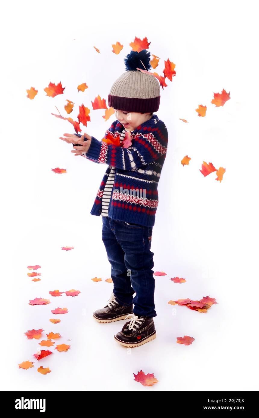 Kleiner Junge, fantasievolles Spiel allein, Herbstblätter fallen Stockfoto