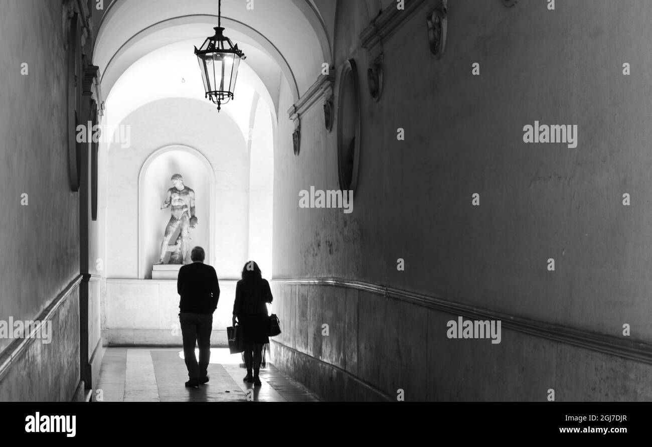 Italien, Rom. Via Ripetta, Blick in die offene Tür des Paares, das durch die lange Halle geht. Stockfoto