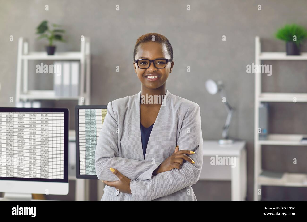 Porträt im Büro einer erfolgreichen, glücklichen dunkelhäutigen Geschäftsfrau, Managerin oder Buchhalterin. Stockfoto