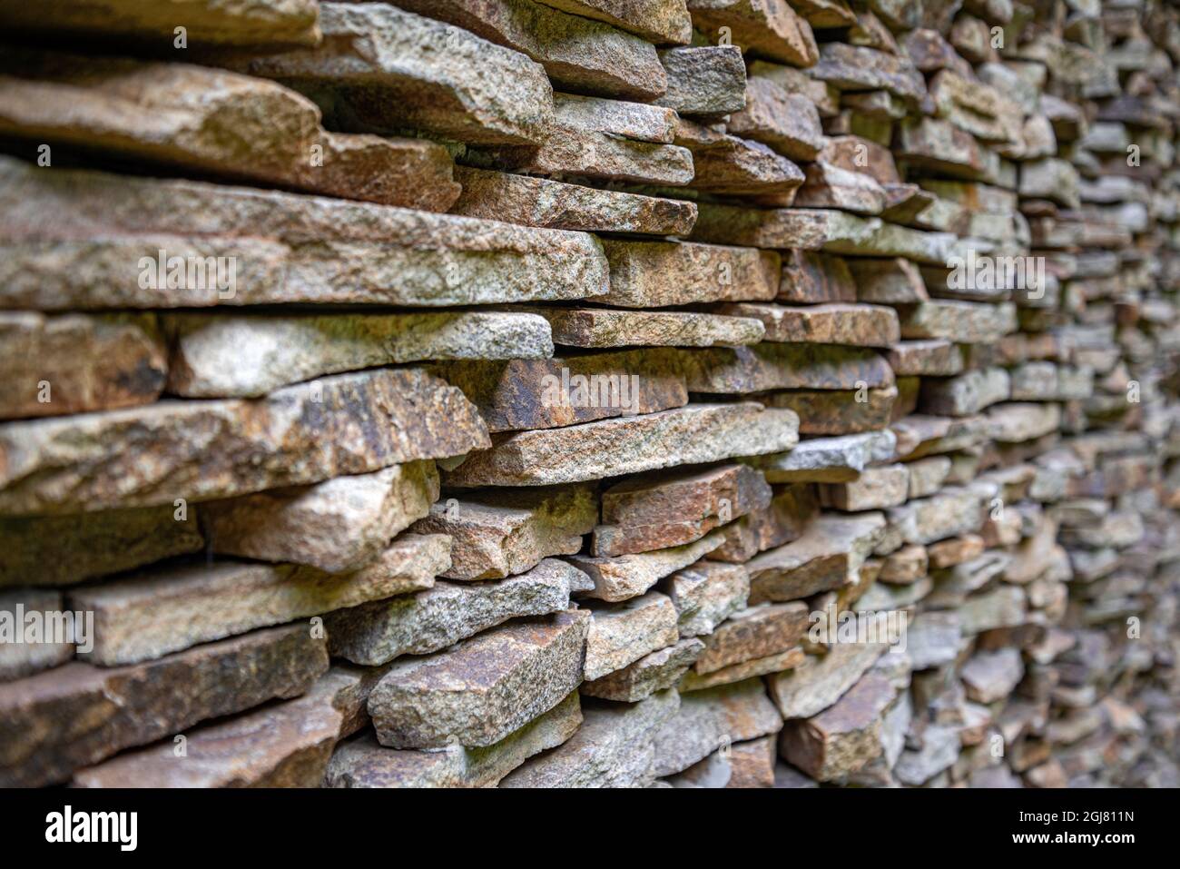 Die Wand ist mit kleinen flachen Steinen ausgekleidet. Stockfoto