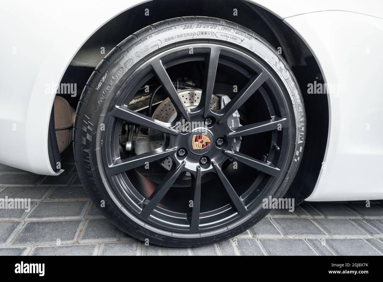 Ukraine, Odessa 8. - 2021. September: Eine Gussscheibe in schwarzer Felge und ein Markenschild in der Mitte für einen Porsche Boxter mit gelochten Bremsen. Porsche Leichtmetallrad mit Michelin Reifen. Stockfoto