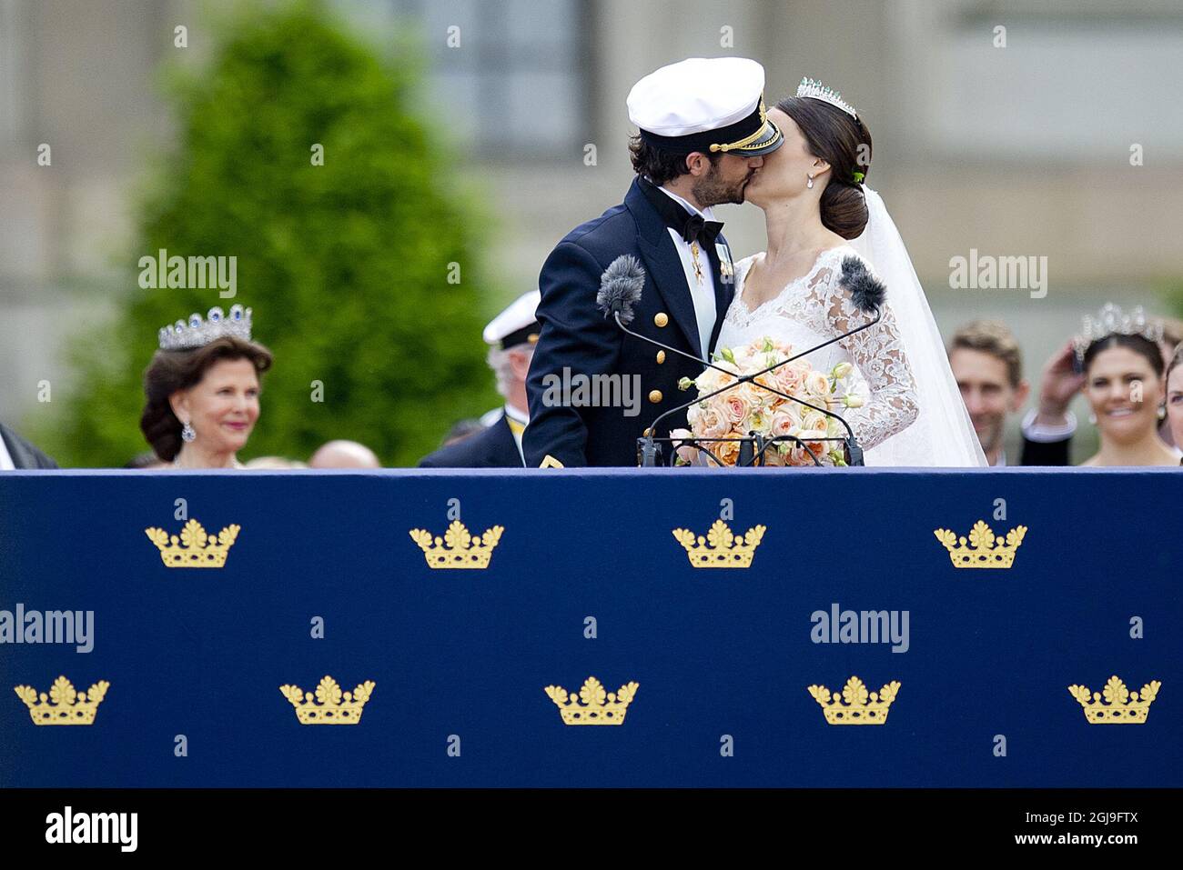 STOCKHOLM, SCHWEDEN 20150613. Hochzeit zwischen Prinz Carl Philip und Sofia Hellqvist. Die frisch verheiratete Braut und Bräutigam Prinz Carl Philip und Prinzessin Sofia küssen sich während der samstags geäußerten Prinzenhochzeit vor der Menge vor dem Königspalast in Stockholm. Hintergrund: Königin Silvia (links) und Kronprinzessin Victoria (rechts). Foto: Jon Olav Nesvold / NTB scanpix Stockfoto