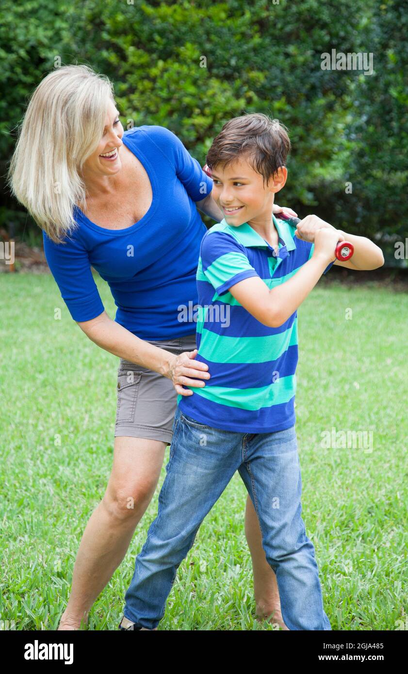 Mutter und Sohn spielen im Hof (MR) Baseballspiele. Stockfoto