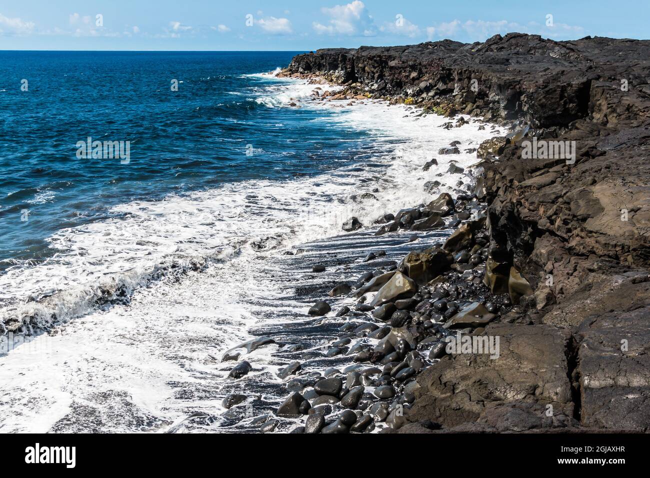 Wellen, die gegen die Meeresklippen krachen, die von den jüngsten Lava-Strömungen am Kaimu Black Sand Beach, Hawaii Island, Hawaii, USA, gebildet wurden Stockfoto