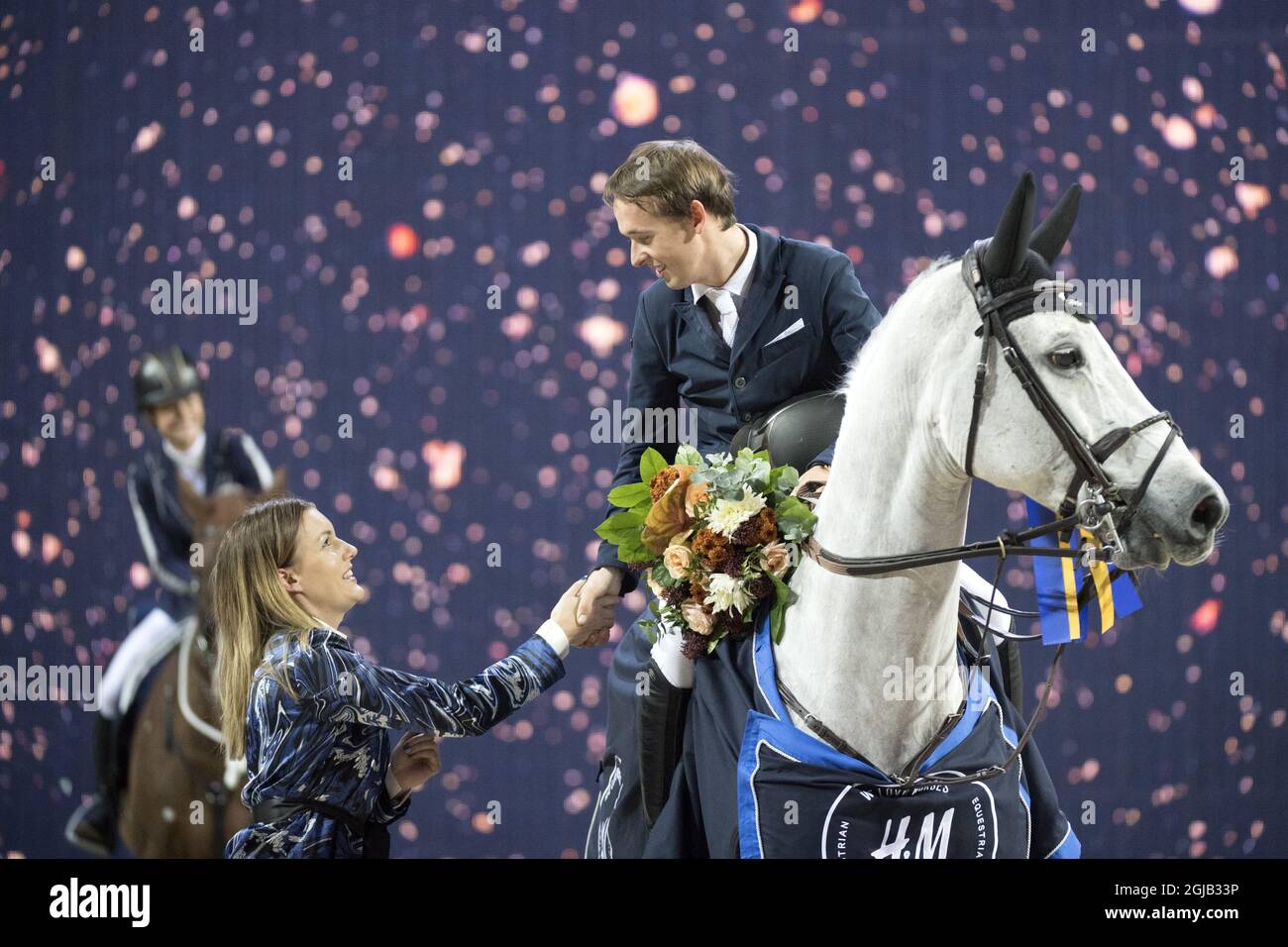 Bertram Allen erhält Blumen, die auf seinem Pferd Gin Chin van het Lindenhof sitzen, nachdem er im Rahmen der Schweden International Horse Show in der Friends Arena in Solna/Stockholm den Grand Prix gewonnen hat. Foto: Jessica Gow / TT / Code 10070 Stockfoto