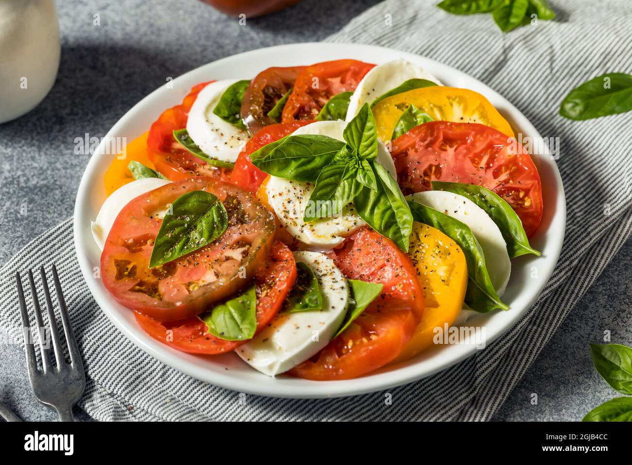 Gesunder, hausgemachter Salat aus Erbstück, Tomaten, Caprese, mit Basilikum und Mozzarella Stockfoto