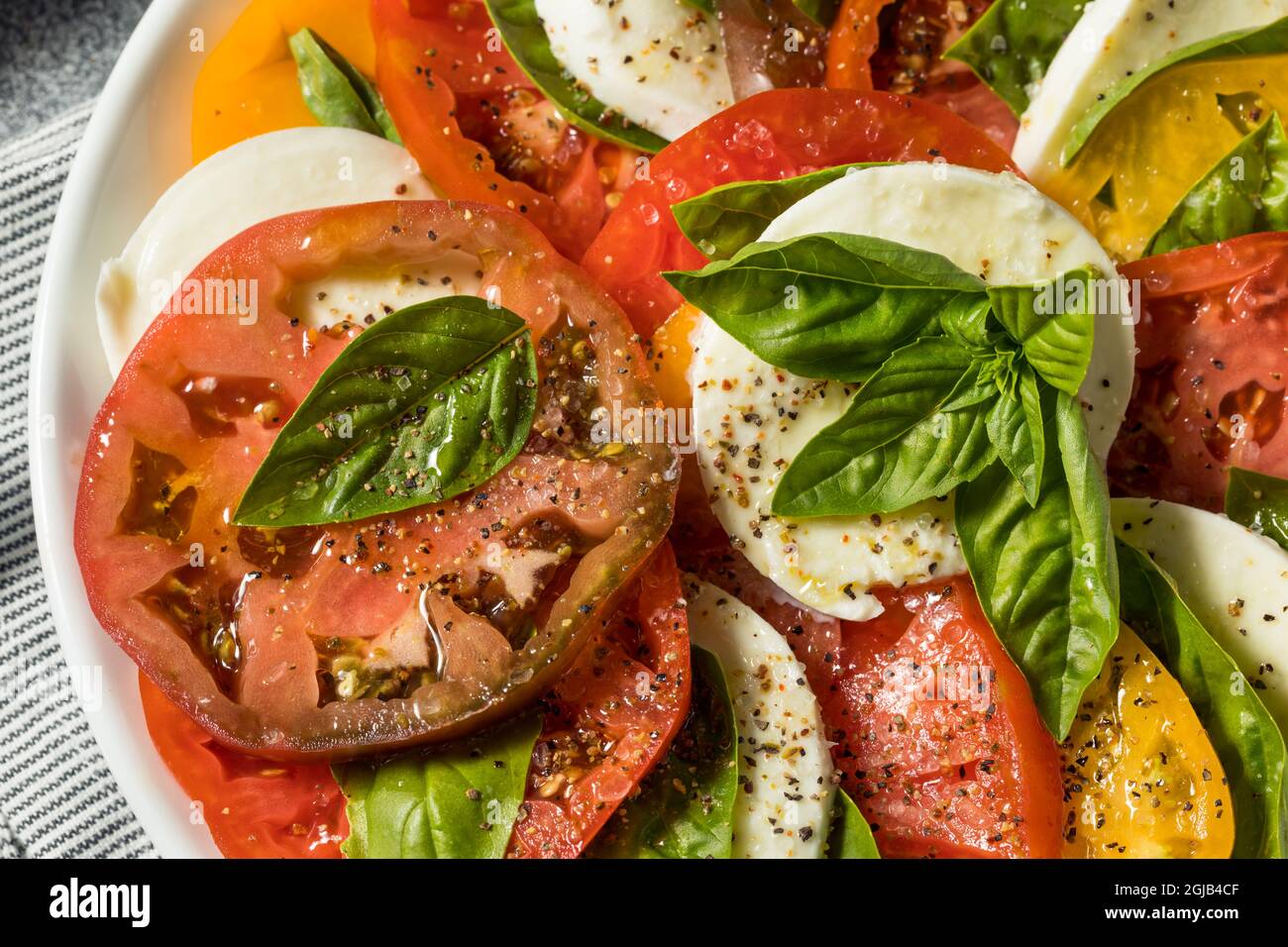 Gesunder, hausgemachter Salat aus Erbstück, Tomaten, Caprese, mit Basilikum und Mozzarella Stockfoto
