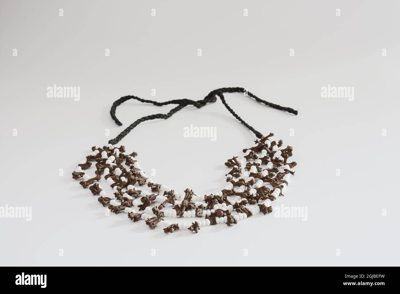 Handgefertigte Halskette aus Nelkensamen. Isolierter weißer Hintergrund Stockfoto