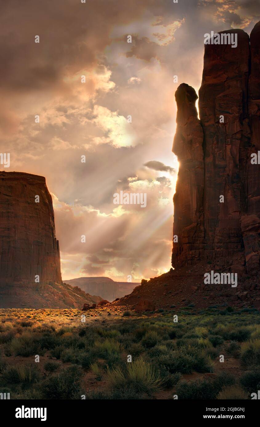Lichtstrahlen filtern nach unten in das Monument Valley, an der Grenze zwischen Arizona und Utah Stockfoto