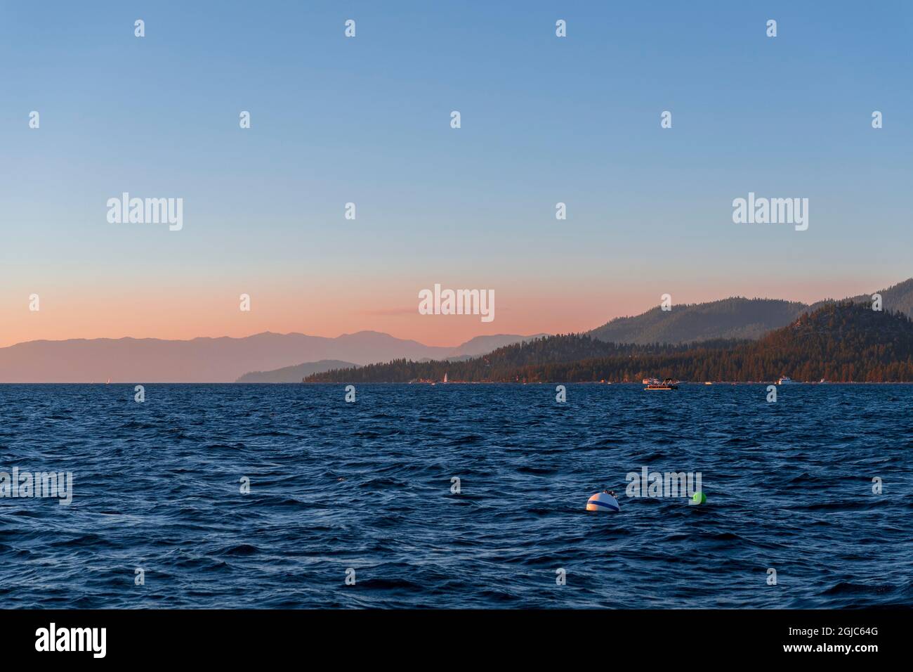 Das tiefblaue Wasser des Lake Tahoe mit Sonnenuntergangsfarben über den Bergen Stockfoto
