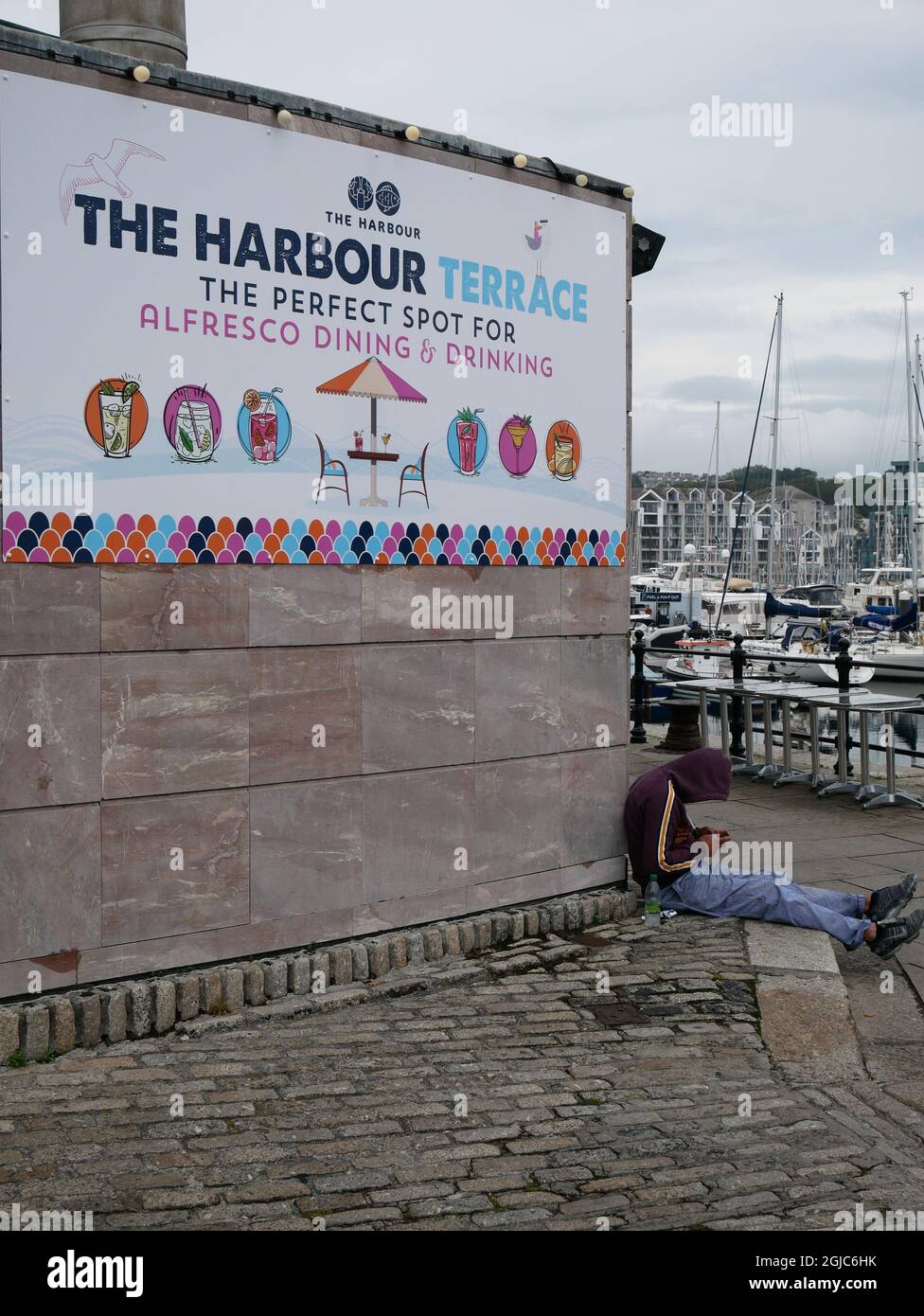 Hospitality Worker macht eine Pause im Restaurantbereich Harbour Terrace, Barbican, Sutton Harbour Marina, Plymout, Devon UK Stockfoto