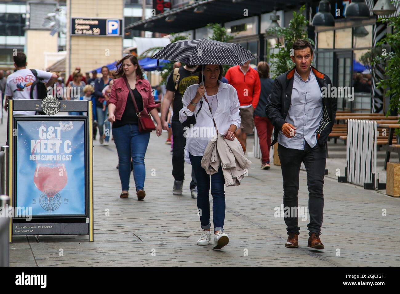 Bristol, Großbritannien. August 2021. Eine Frau wird bei Regen neben einem Schutzdach eines Mannes unter einem Regenschirm laufen gesehen. (Foto: Dinendra Haria/SOPA Images/Sipa USA) Quelle: SIPA USA/Alamy Live News Stockfoto