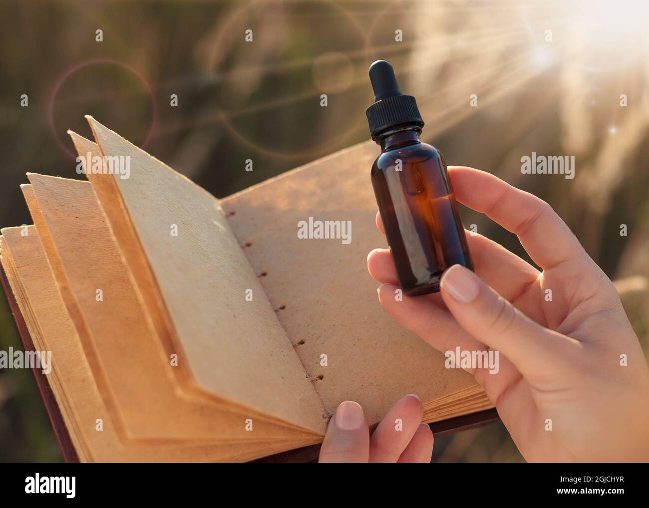 Kräuterextrakt in einer Pipette - Platz für Text kopieren. Eine Frau, die eine medizinische Flasche und ein leeres Notizbuch in der Hand hält. Alternative Medizin - NACHBAU. Stockfoto
