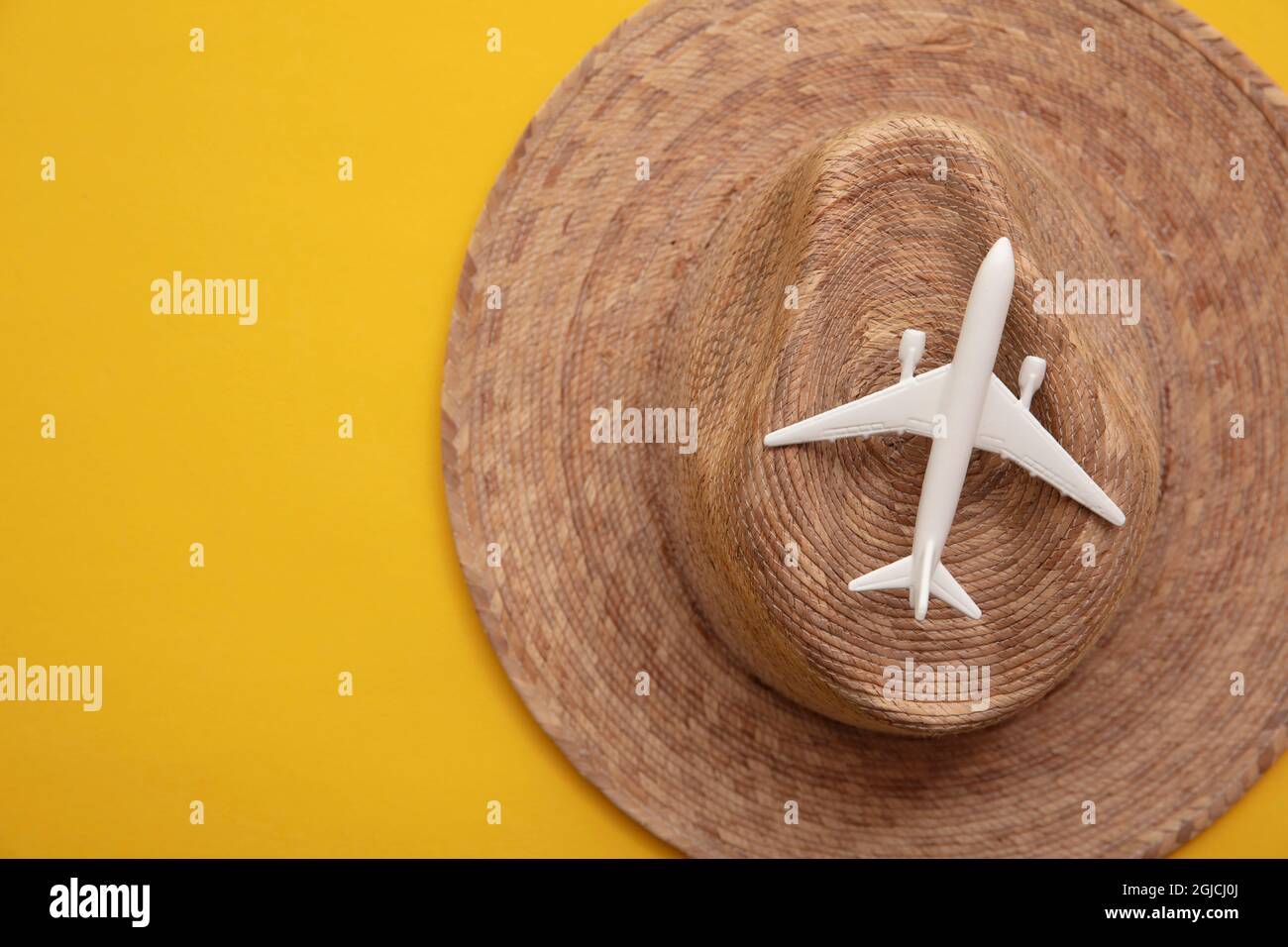 Modellflugzeug auf einem Strohhut. Sommerurlaub Urlaub Hintergrund Stockfoto