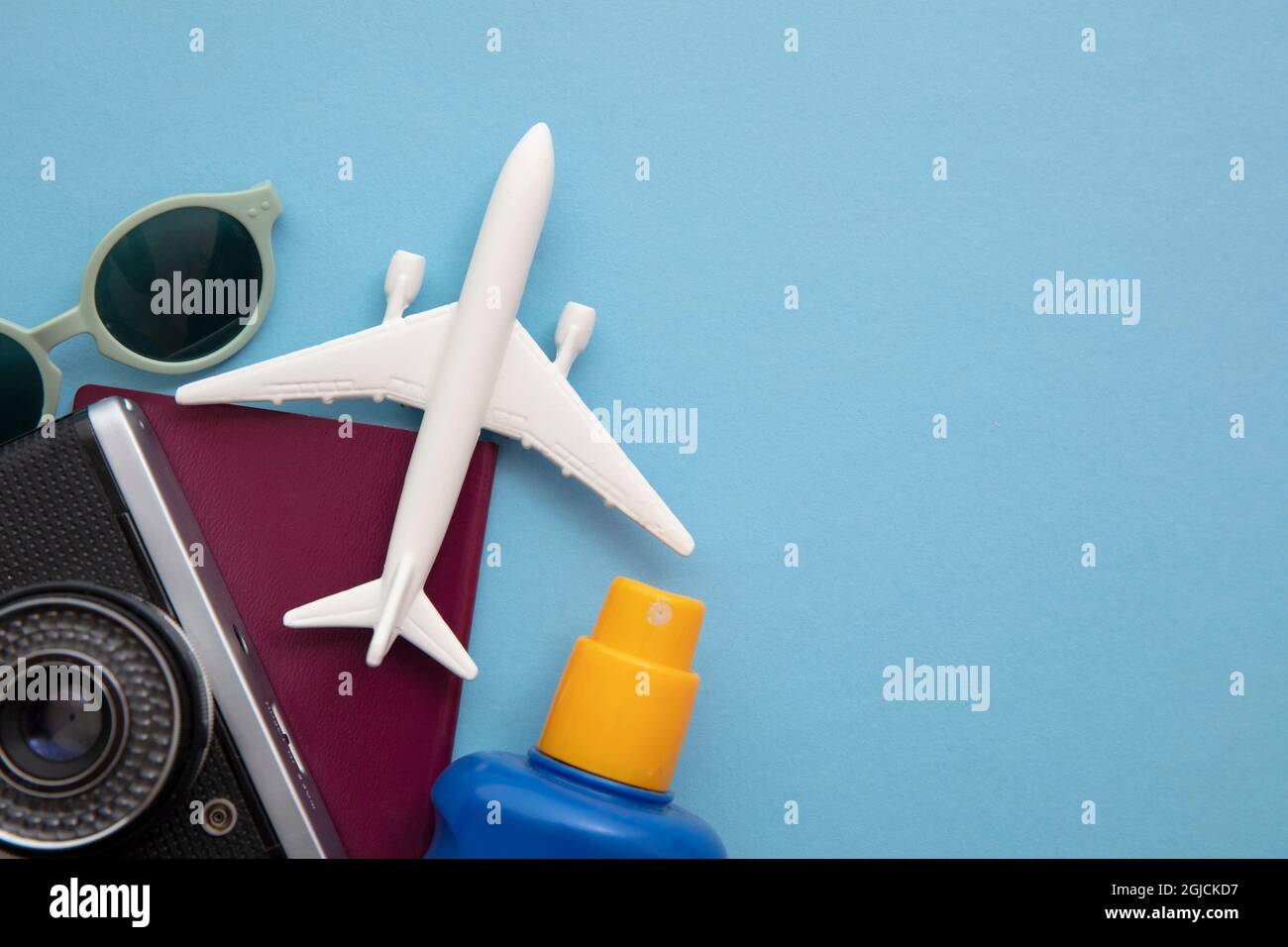 Ansicht von oben mit einem Spielzeug-Flugzeug auf blauem Hintergrund von wichtigen Urlaubsartikeln Stockfoto