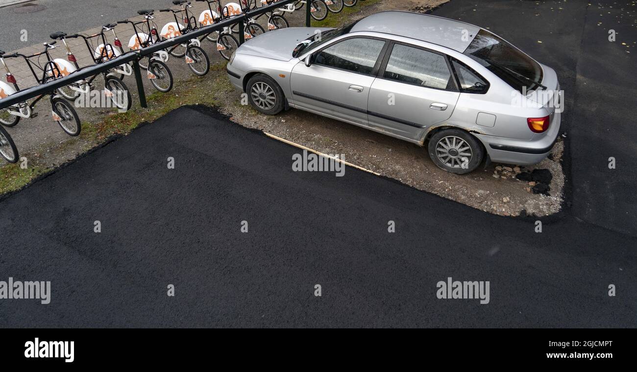 Pflasterfehler in Malmoe. Ein illegal geparktes Auto war auf einem Parkplatz im Einkaufszentrum Triangeln zurückgelassen worden, als die Arbeiter ankamen, um das Gebiet zu pflastern. Anstatt das Auto abzuschleppen, lösten sie das Problem, indem sie es einfach umpflasterten... Malmoe, Schweden, 12. Oktober 2019. Foto: Johan Nilsson / TT / Code 50090 Stockfoto