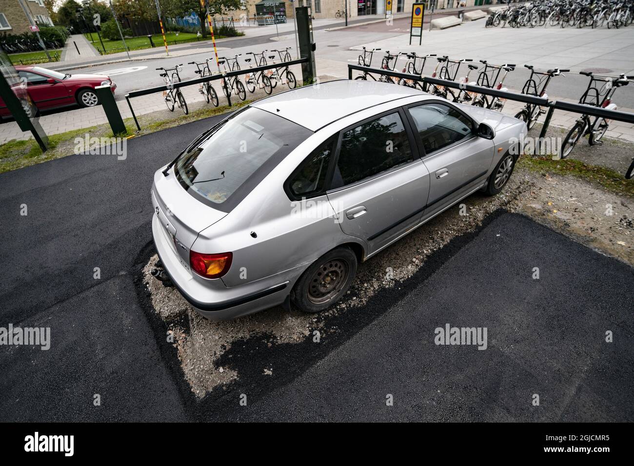 Pflasterfehler in Malmoe. Ein illegal geparktes Auto war auf einem Parkplatz im Einkaufszentrum Triangeln zurückgelassen worden, als die Arbeiter ankamen, um das Gebiet zu pflastern. Anstatt das Auto abzuschleppen, lösten sie das Problem, indem sie es einfach umpflasterten... Malmoe, Schweden, 12. Oktober 2019. Foto: Johan Nilsson / TT / Code 50090 Stockfoto
