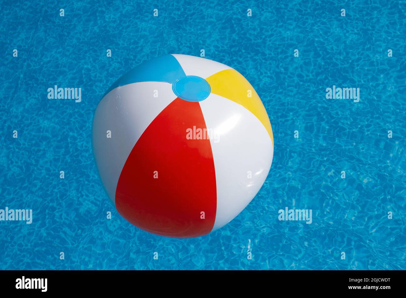 Aufblasbarer Strandball schwimmt im Schwimmbad Stockfoto