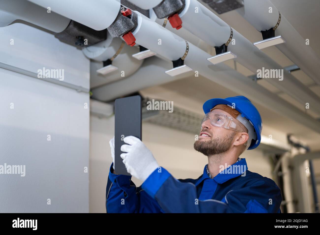 Inspektion der PVC-Wasserleitung durch den Bauarbeiter Stockfoto