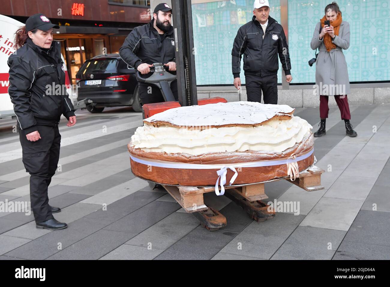 Die schwedische Bäckerei Bake My Day hat einen Guinness-Weltrekord aufgestellt, indem sie das größte Semla der Welt, ein schwedisches Rahmbrötchen, gebacken hat. Die Bäckerei verwendete 115 Liter Rahm, 30 kg Marzipan und 20 kg Puderzucker. Es wiegt 300 kg und hat 18 Stunden gebraucht, um es zu machen. Der Bäcker Daniel Granholm hält einen normal großen Semla in der Hand. Foto: Jonas Ekstromer / TT kod 10030 Stockfoto