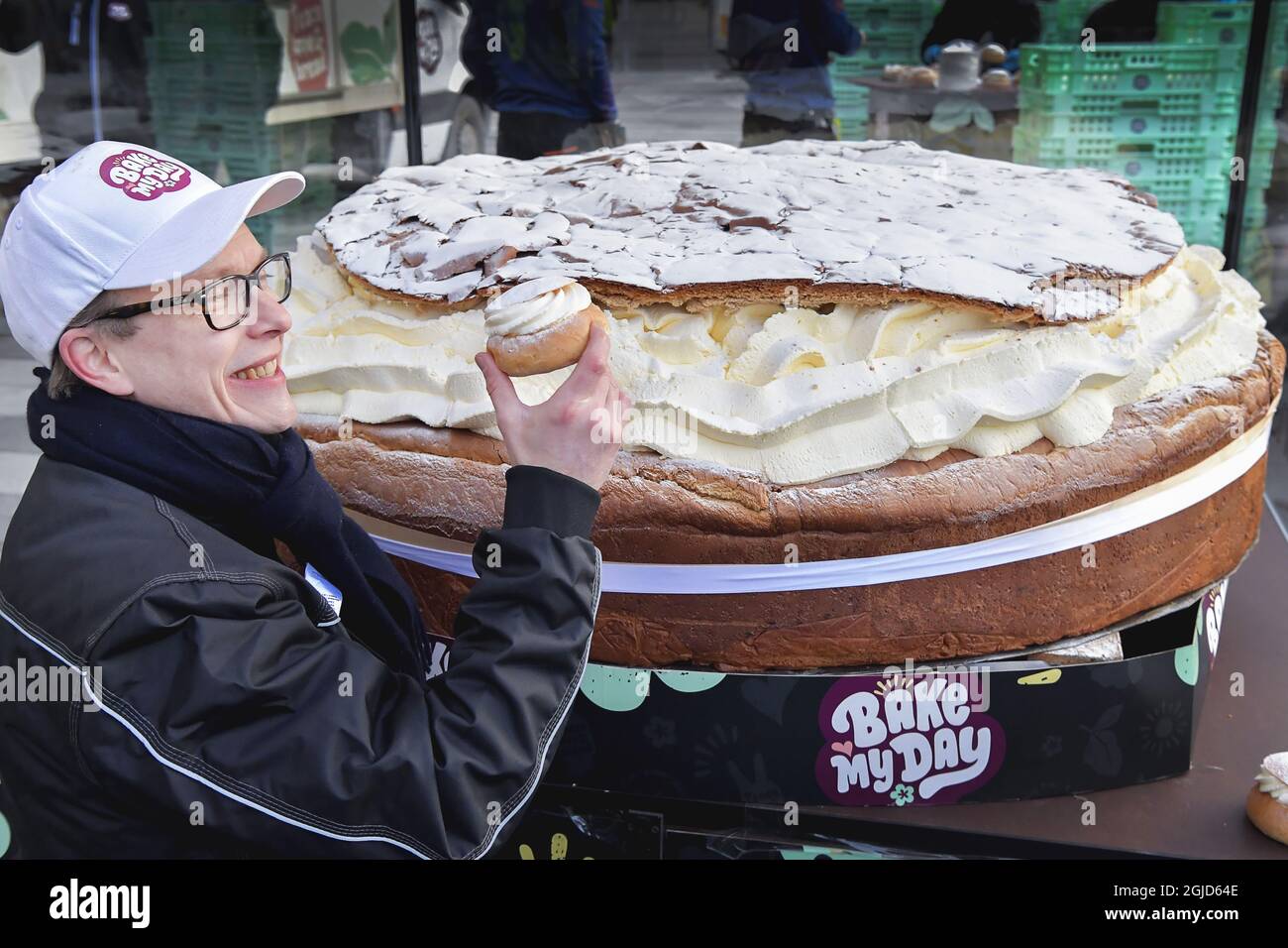 Die schwedische Bäckerei Bake My Day hat einen Guinness-Weltrekord aufgestellt, indem sie das größte Semla der Welt, ein schwedisches Rahmbrötchen, gebacken hat. Die Bäckerei verwendete 115 Liter Rahm, 30 kg Marzipan und 20 kg Puderzucker. Es wiegt 300 kg und hat 18 Stunden gebraucht, um es zu machen. Der Bäcker Daniel Granholm hält einen normal großen Semla in der Hand. Foto: Jonas Ekstromer / TT kod 10030 Stockfoto