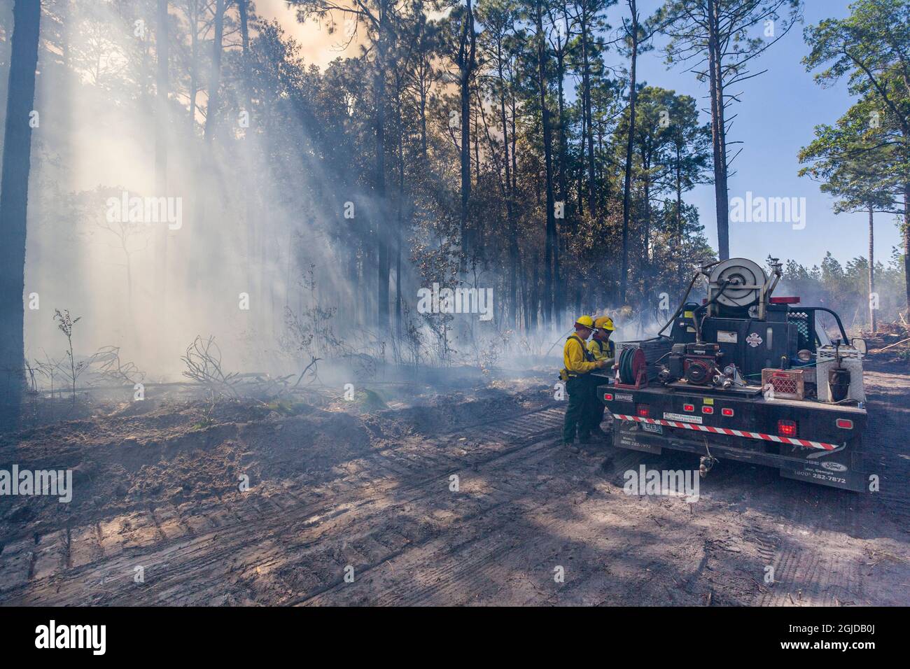 Die Feuerwehr bereitet sich darauf vor, Wasser auf Flammen zu sprühen. Stockfoto