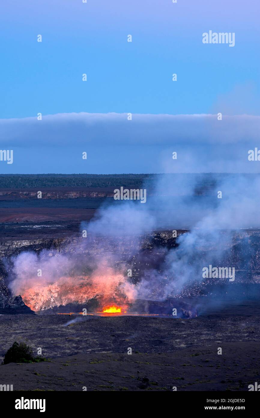 USA, Hawaii, Big Island of Hawaii. Hawaii Volcanoes National Park, Lava und Dampfausbruch am Halemaumau Krater am Abend. Stockfoto