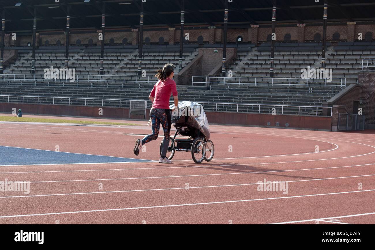 Eine Mutter mit einem Kinderwagen joggt auf den Laufstrecken im Stockholmer Stadion. Foto: Henrik Isaksson / TT / Code 2838 Stockfoto