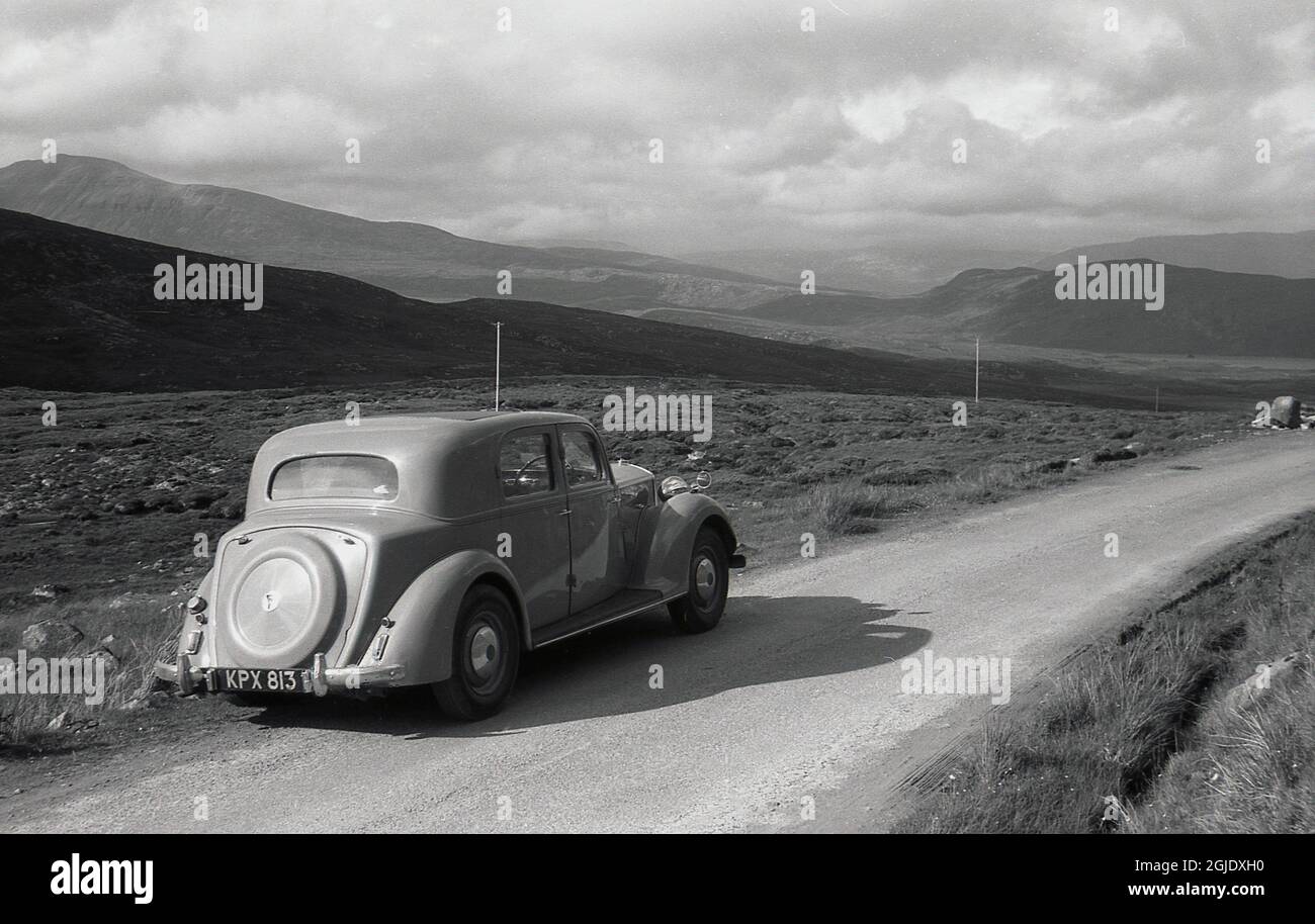 1950er Jahre, historisches Bild, Autofahren im schottischen Hochland, ein britischer Automobile, ein Rover 75 P3 4-Light-Sportlimousine, geparkt auf einer schmalen Landstraße, mit dem Hochland in der Ferne, Schottland, Großbritannien. Stockfoto