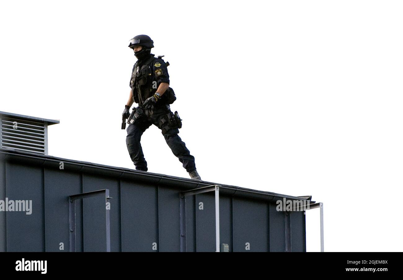 Ein Polizei-swat-Team auf dem Dach eines Gelddepots in Vastberga, Stockholm, Schweden. Räuber nutzten einen Hubschrauber, um am frühen Mittwochmorgen einen spektakulären Diebstahl an einem Gelddepot südlich von Stockholm durchzuführen. Stockfoto