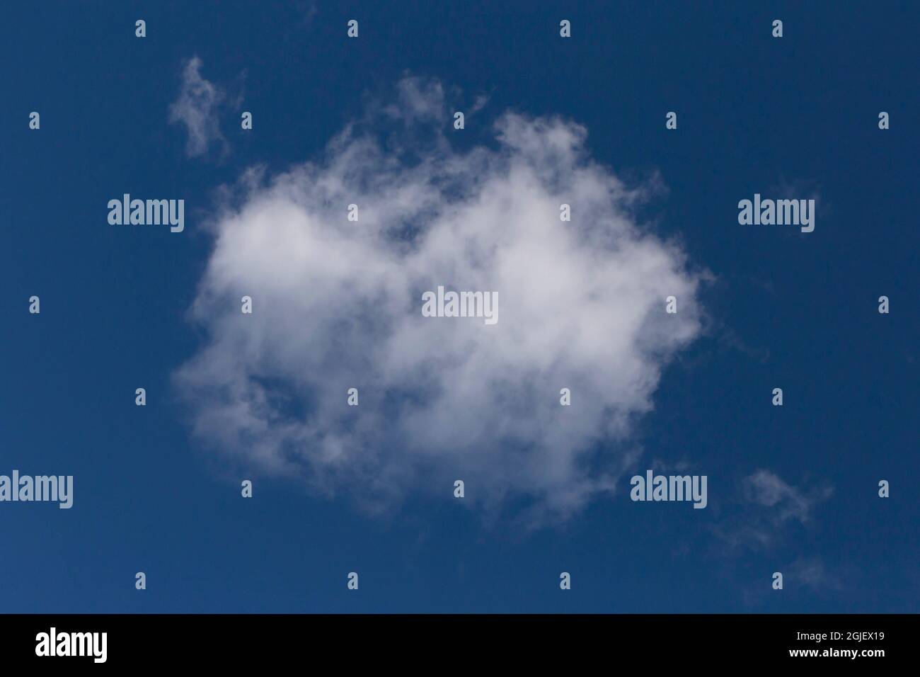Blick auf eine einzige weiße Wolke in einem klaren blauen Himmel Stockfoto