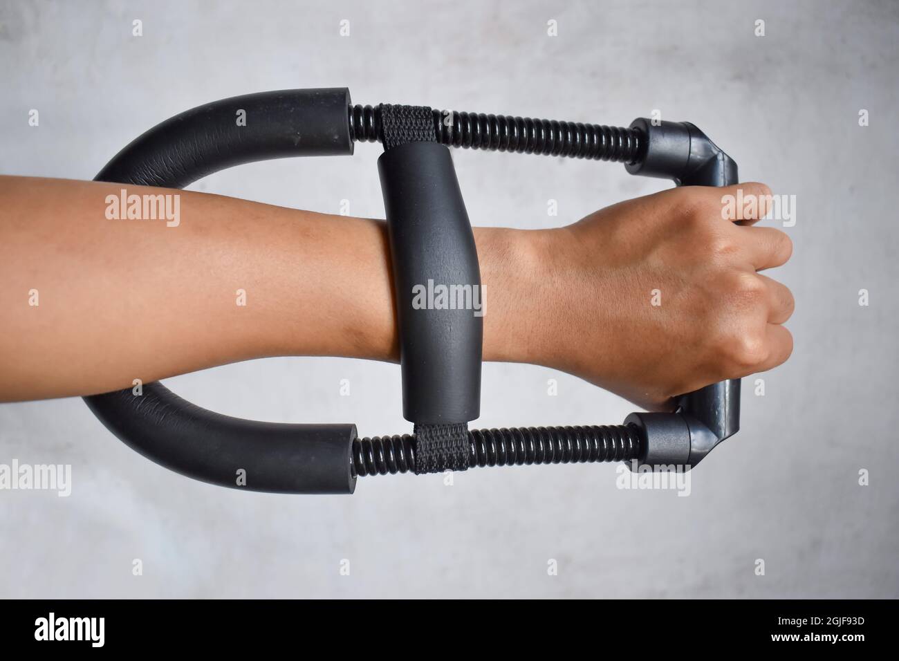 Werkzeug zur Verstärkung des Handgelenks und des Unterarms. Leichtes Workout für Zuhause von einem Mann. Isoliert auf Weiß. Nahaufnahme. Stockfoto