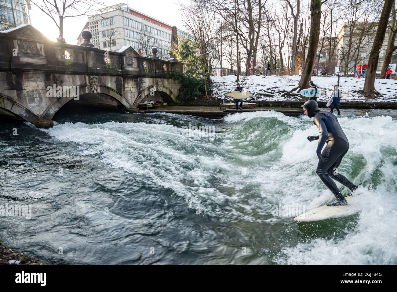 Surfer fahren stromaufwärts im Eisbach in München. Stockfoto