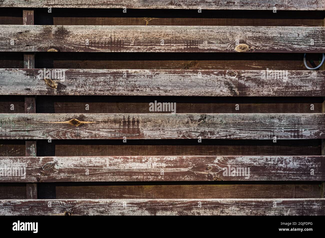 Hintergrund von alten Brettern. Horizontale Holzstreifen. Alte, schäbige Holzplanken. Holzleisten. Vorderansicht. Stockfoto