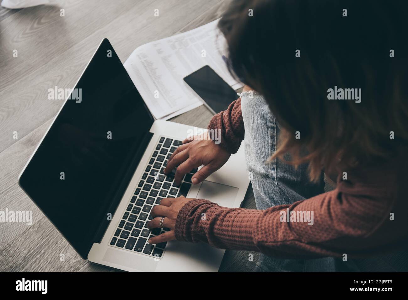 Junge Frau, die zu Hause am Laptop arbeitet. Weibliche Hände tippen auf der pc-Tastatur. Tennager, der einen Internet-Videoanruf mit entfernten Freunden führt. Mädchen, das o studiert Stockfoto
