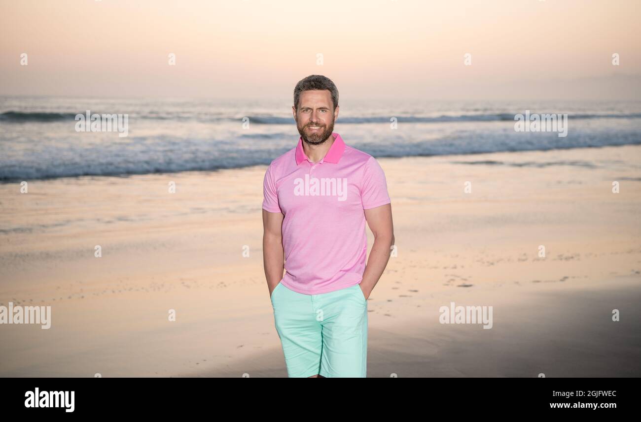Glücklicher Mann über dem Meer auf Sonnenuntergang Sommer Strand, Seestücke Stockfoto