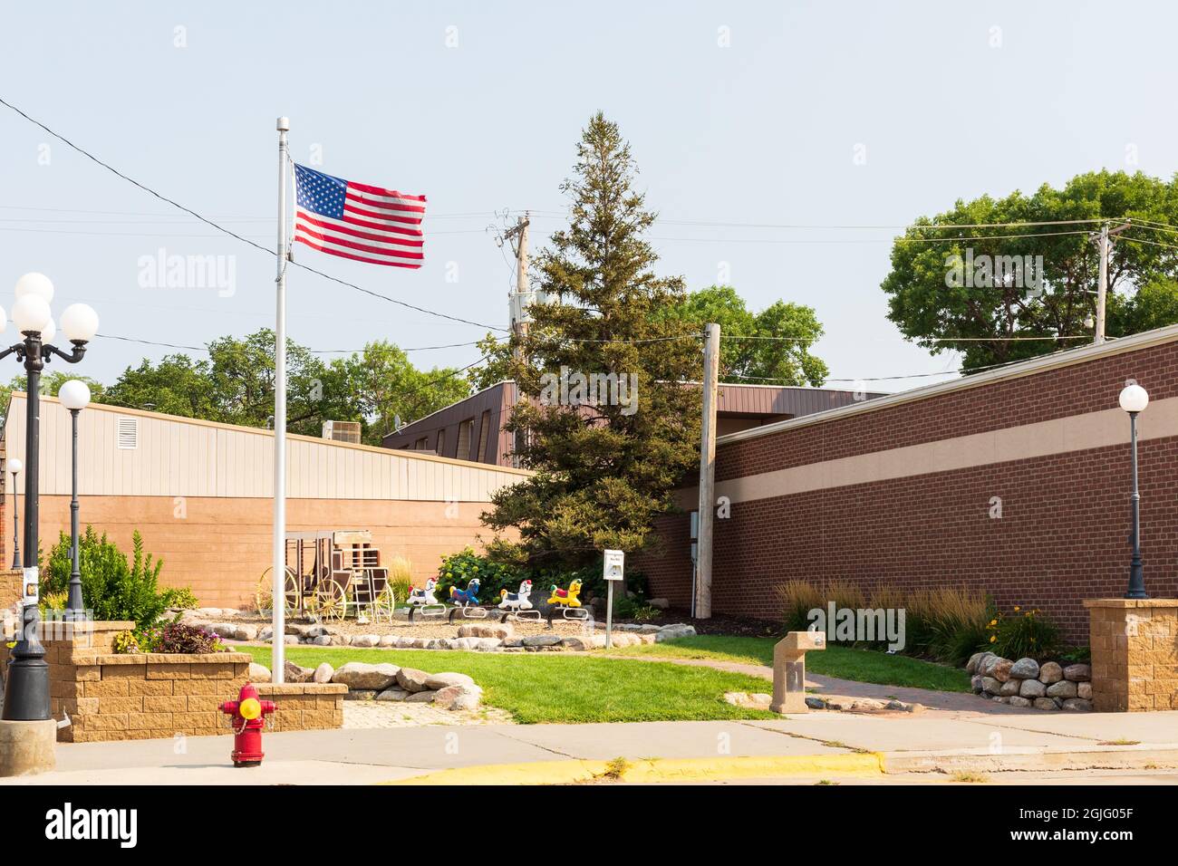 Chamberlain, SD, USA-24 AUGUST 2021: Kleiner Stadtpark mit Hobbypferden, einem Kinderklettergerät aus einem Wagen und einem Fahnenmast. Stockfoto