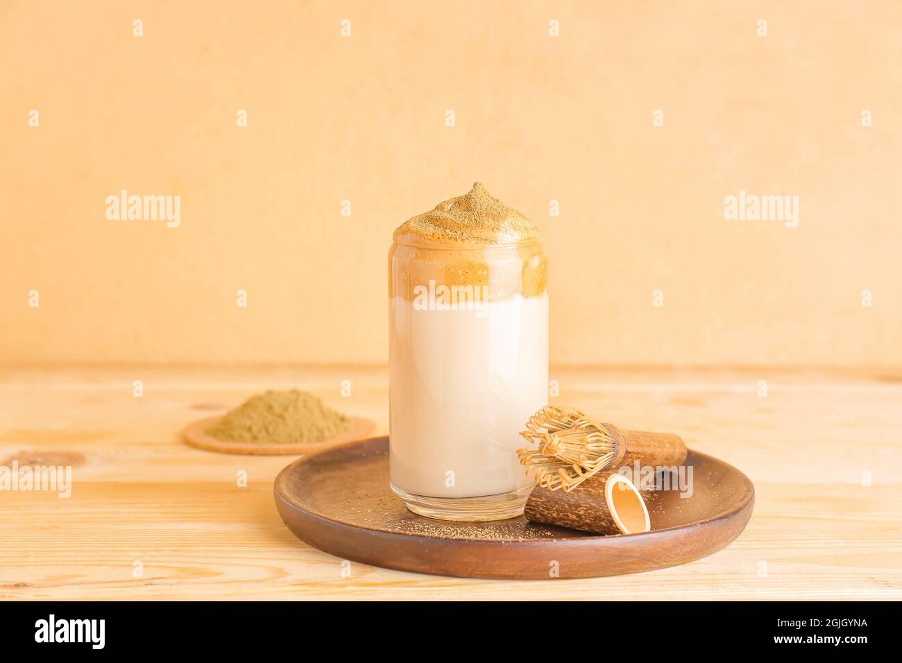 Ein Glas leckeren dalgona hojicha Latte und Chasen auf dem Tisch Stockfoto