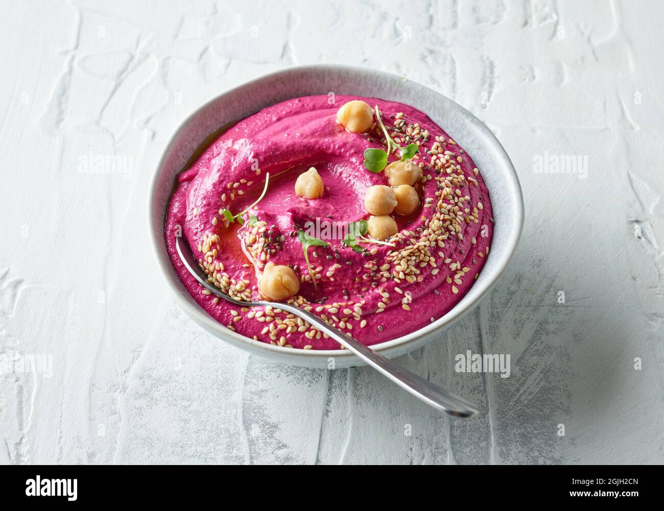 Schüssel Rote Beete Hummus auf hellem Küchentisch Stockfoto