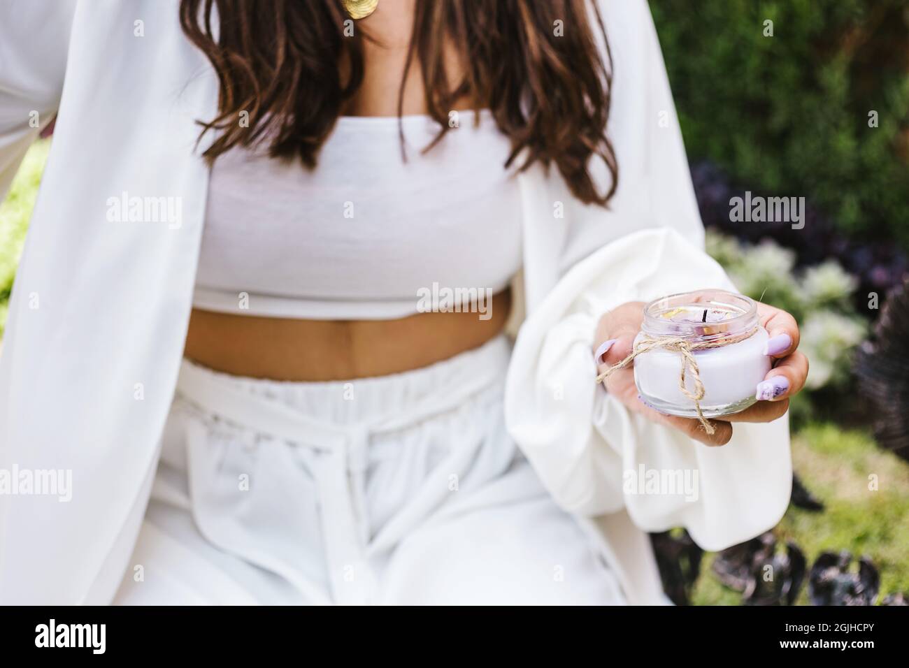 Hand einer jungen hispanischen Frau mit einer weißen Kerze in einer ganzheitlichen Therapie in Lateinamerika Stockfoto